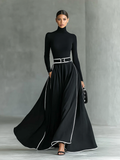 Gina – Vestido largo de mujer negro con costuras blancas, cuello alto, mangas largas y cintura estrecha